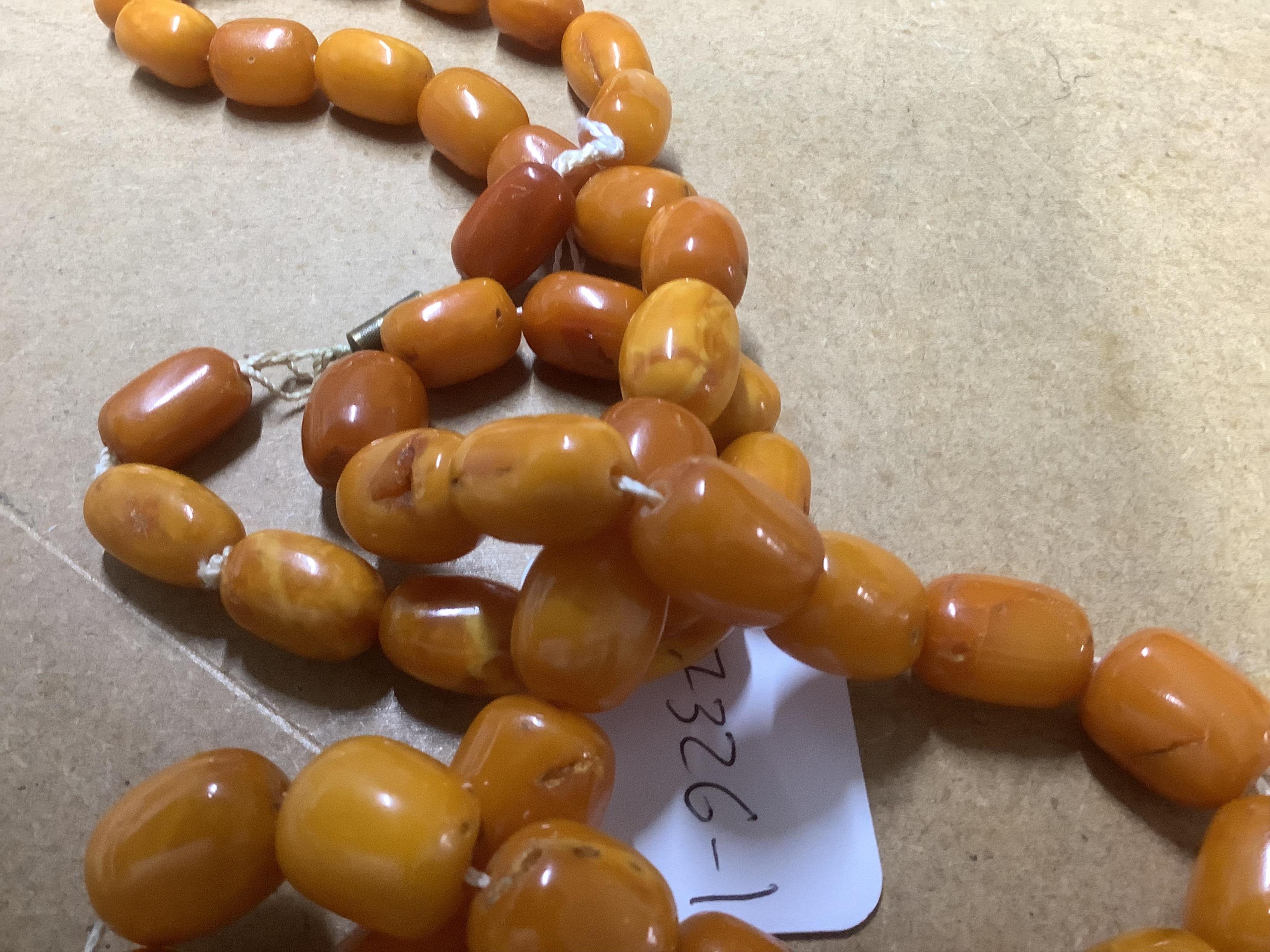 A single strand oval and barrel shaped amber bead necklace, 90cm, gross weight 102 grams. Condition - poor to fair